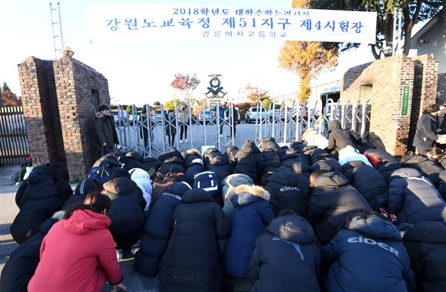 2018학년도 대학수학능력시험이 진행된 23일 강원 강릉여고 고사장 앞에서 후배들이 수험생들의 고득점을 기원하며 큰절을 하고 있다. 연합뉴스