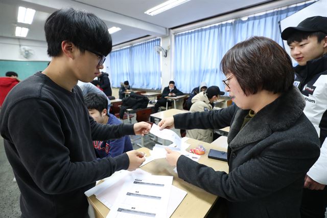 24일 오전 서울 여의도고에서 2018학년도 대학수학능력시험을 응시한 학생들이 선생님과 가채점 결과를 확인하고 있다. 연합뉴스