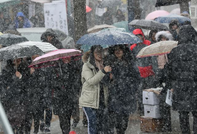 수능 이후 주요 대학 논술·면접이 시작된 주말인 25일 오전 서울 종로구 성균관대에서 수험생과 학부모들이 눈을 맞으며 논술 고사장으로 향하고 있다.연합뉴스