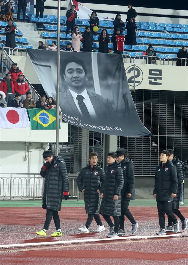 부산 선수들이 26일 상주시민운동장에서 열린 프로축구 승강 플레이오프에서 상주 상무에 패해 1부 리그 승격에 실패한 뒤 허탈한 표정으로 고 조진호 감독 사진 앞을 지나가고 있다. 상주=연합뉴스