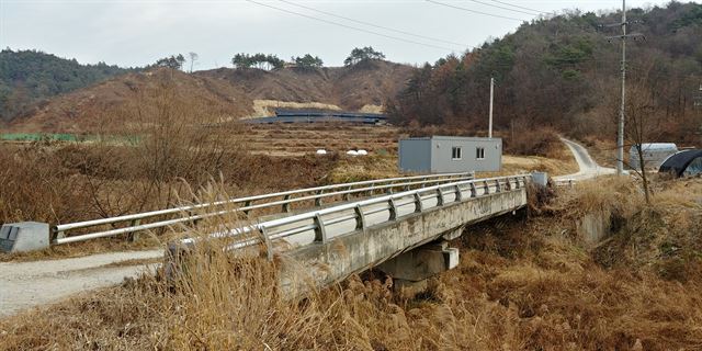 영주시가 주민반발과 환경부의 부적합 판단에도 불구하고 대형 돈사 신축 허가를 내줘 물의를 빚고 있다. 하천 다리 건너 산밑 구릉지가 돈사 예정지. 이용호기자