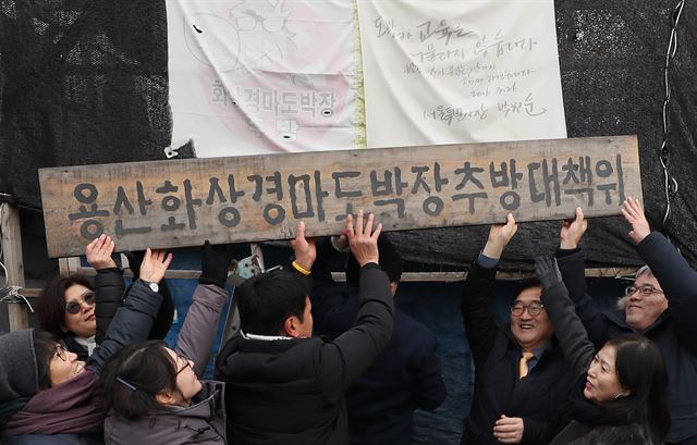 4일 오후 서울 용산구 화상경마도박장 농성장에서 열린 용산화상경마도박장 폐쇄 기념 조형물 제막식 및 대책위 해단식에서 대책위 관계자들과 더불어민주당우원식 원내대표(오른쪽 세번째)등이 대책위 현판을 내리고 있다. 서울=연합뉴스