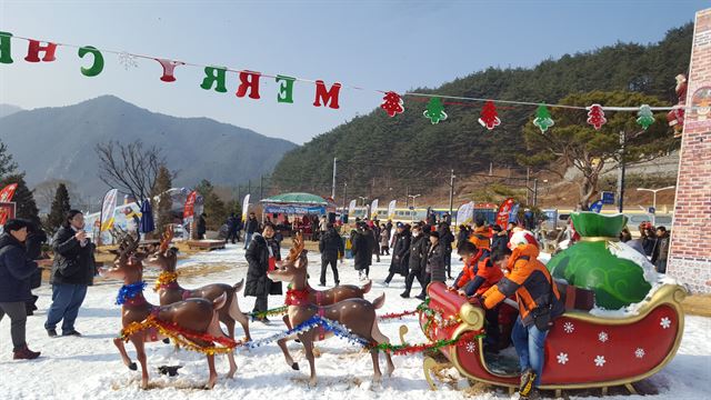 봉화 분천역 산타마을을 방문한 관광객들이 모형 산타썰매를 타며 즐거워하고 있다. 봉화군 제공