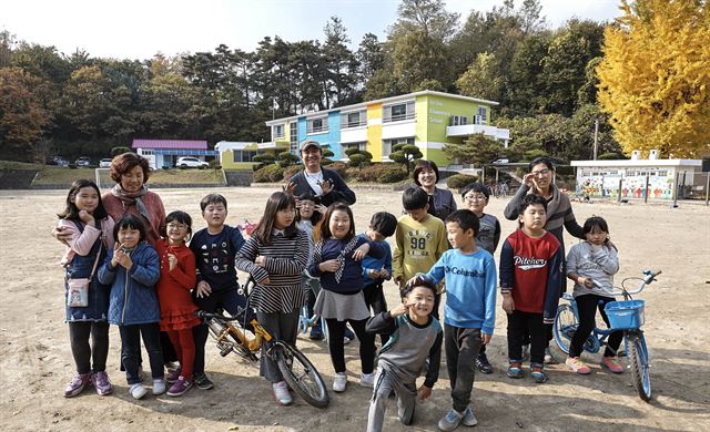 김재식(맨 뒤)씨가 지난해 도색 재능기부를 한 강릉 옥천초 운산분교 학생들과 기념촬영을 하고 있다. 강원교육청 제공