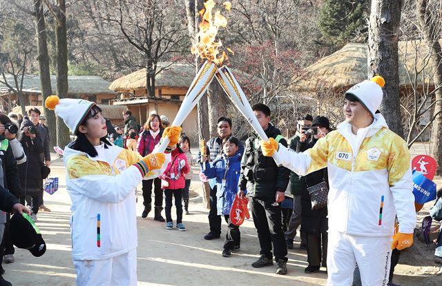 6일 오후 경기도 용인시 한국민속촌에서 열린 2018 평창동계올림픽 성화 봉송 행사에서 주자들이 토치 키스를 하고 있다. 연합뉴스