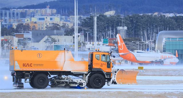 폭설이 내린 11일 오전 제설차량이 제주국제공항 활주로에서 눈을 치우고 있다. 연합뉴스.