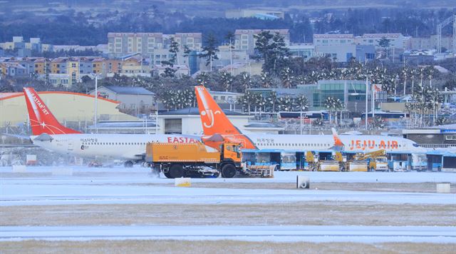 폭설이 내린 11일 오전 제설차량이 제주국제공항 활주로에서 눈을 치우고 있다. 연합뉴스