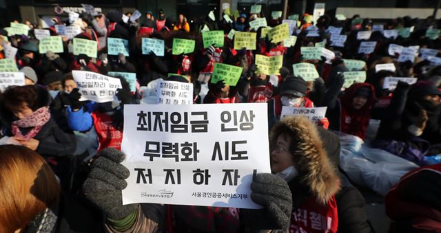 11일 서울 광화문 일자리위원회 앞에서 열린 임금인상 무력화 위한 '인원감축 꼼수 정부의 대책 마련 촉구를 위한 투쟁결의대회'에서 참석한 대학 청소·경비노동자 등이 구호를 외치고 있다. 연합뉴스