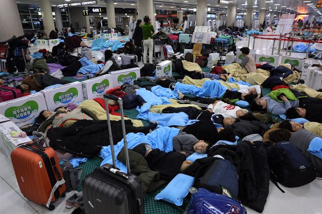 12일 오전 제주공항 3층 출발대합실에서 노숙한 전날 결항 항공편 어린이 승객들이 꿈나라 여행을 하고 있다. 연합뉴스.