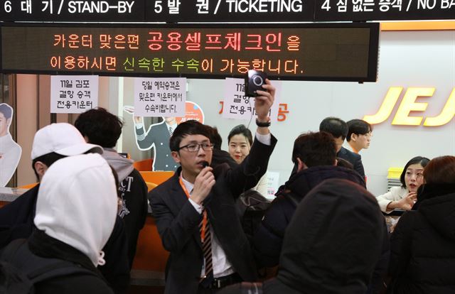 12일 오전 제주공항 내 제주항공 발권 카운터 앞에서 한 직원이 전날 결항 항공편 승객들을 대상으로 안내방송을 하고 있다. 연합뉴스.