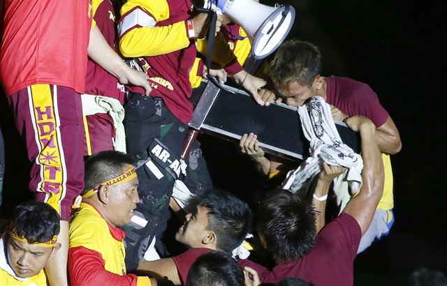 블랙 나자렌 축제가 열린 필리핀 마닐라에서 한 로마 카톨릭 신자가 검은 예수상의 십자가에 입을 맞추고 있다. AP 연합뉴스