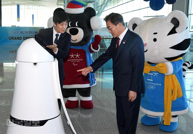 문재인 대통령이 12일 인천국제공항 제2터미널 개장식에서 스마트 공항 체험 일환으로 무인안내 로봇의 안내를 받으며 입장하고 있다. 인천국제공항=고영권기자