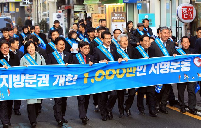 이시종(앞줄 오른쪽에서 다섯번째)충북지사, 이범석(오른쪽에서 두번째)청주시장 권한대행과 민간 사회단체 회원들이 15일 ‘지방분권 개헌 1,000만인 서명운동’ 동참을 호소하는 펼침막을 들고 청주도심 성안길을 행진하고 있다. 충북도 제공