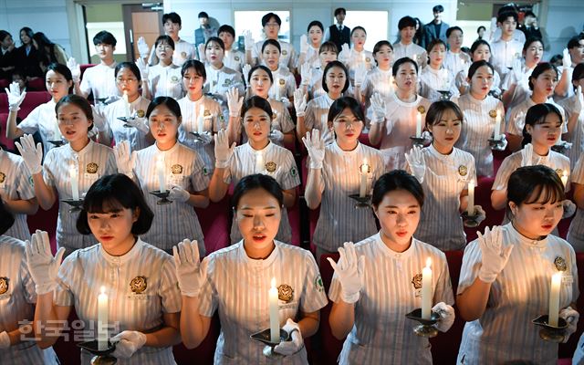 지난해 11월 부산 남구 동명대 중앙도서관 대회의실에서 열린 '제5회 간호학과 나이팅게일 선서식'에 참가한 간호학과 4학년 재학생 81명이 촛불을 들고 인류애와 생명존중 등 간호정신 실천을 다짐하고 있다. 전혜원 기자 iamjhw@hankookilbo.com