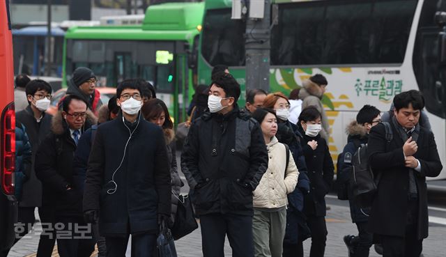 서울시가 두번째 미세먼지 비상저감조치를 발령한 17일 오전 서울 광화문에서 마스크를 착용한 출근길 시민들이 발걸음을 재촉하고 있다배우한 기자