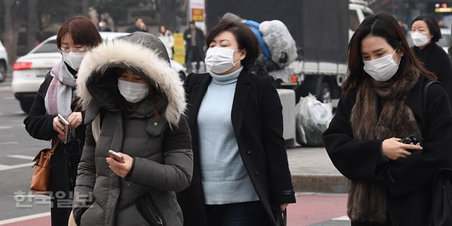 서울시가 두번째 미세먼지 비상저감조치를 발령한 17일 오전 서울 광화문에서 마스크를 착용한 출근길 시민들이 발걸음을 재촉하고 있다배우한 기자