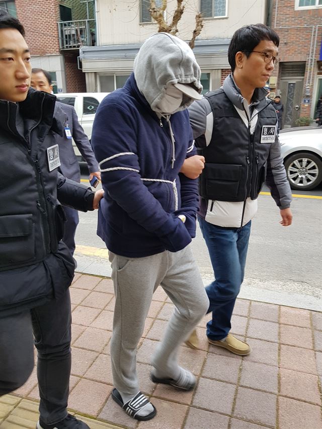 경찰이 22일 오전 경남 진주시내 한 주택 앞에서 친구 A(39)로부터 사주를 받아 친구 어머니를 살해한 혐의를 받는 B(39) 씨를 상대로 현장검증을 하고 있다. 연합뉴스