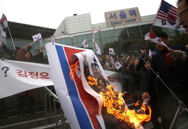 현송월 삼지연 관현악단 단장이 이끄는 북한 예술단 사전 점검단이 서울역에 도착한 22일 오전 서울역에서 보수단체가 인공기와 김정은 사진을 태우고 있다. /심현철기자 shim@koreatimes.co.kr /2018-01-22(코리아타임스)