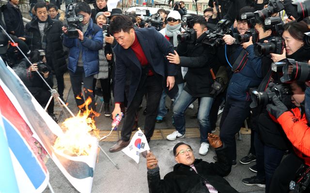 22일 오전 서울역 광장에서 보수단체 회원이 인공기 등을 불태우는 장면을 취재진이 촬영하고 있다. 연합뉴스