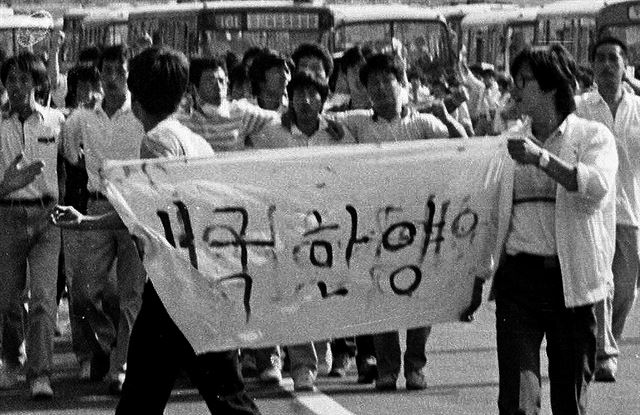 [애국한양] 1987년 6월 민주화 투쟁에 나선 ‘애국한양’대학교 학생들이 학교 FM을 적은 흰 천을 앞세우고 거리 행진을 벌이고 있다.