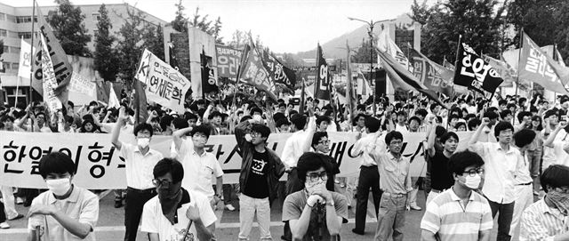 [민주화 투쟁 시대 만들어진 FM] 1987년 6월 서울 연세대학교 앞에서 학생들이 각 단과대와 학과, 동아리 FM이 적힌 깃발을 앞세우고 폭력경찰규탄 집회를 하고 있다.