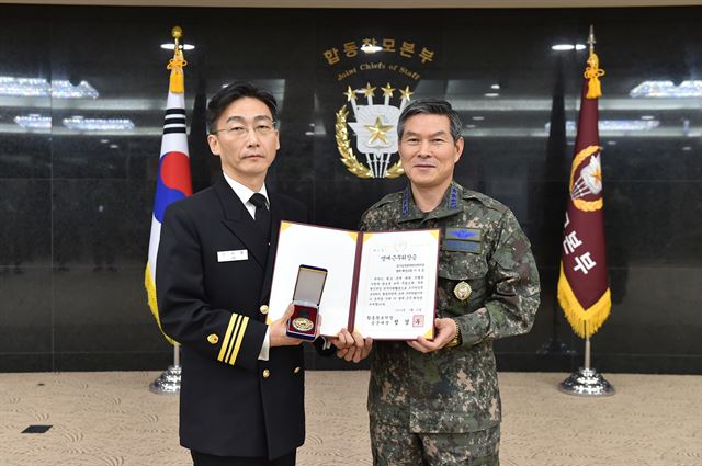 명예합참인으로 위촉된 이국종(왼쪽) 아주대 의과대학 교수가 25일 합참휘장을 받고 정경두 합참의장과 기념촬영을 하고 있다. 합참제공