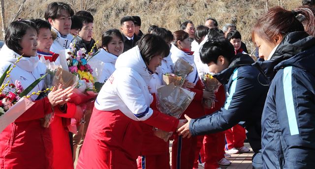 우리나라와 단일팀을 구성해 평창동계올림픽에 출전할 북한 여자 아이스하키 선수단이 25일 오후 충청북도 진천군 국가대표선수촌 빙상훈련장에 도착, 환영식에서 한국 아이스하키 대표 선수들이 꽃다발을 주고 있다.사진공동취재단