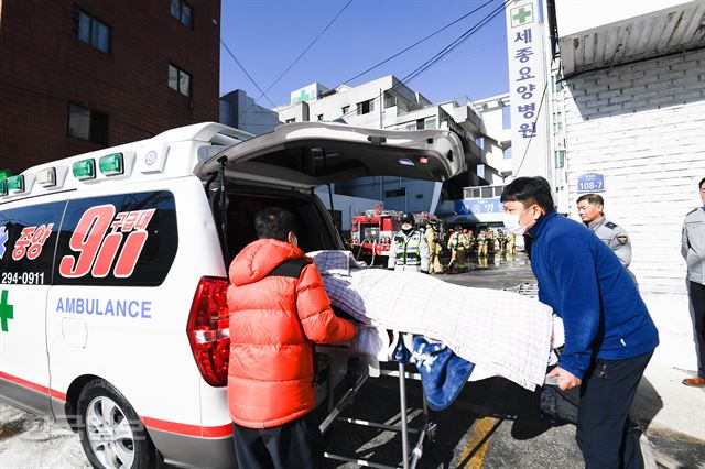 26일 오전 7시 30분쯤 경남 밀양시 가곡동 세종병원에서 불이나 소방대원들과 관계자들이 환자들을 이송하고 있다. 밀양=전혜원 기자 iamjhw@hankookilbo.com