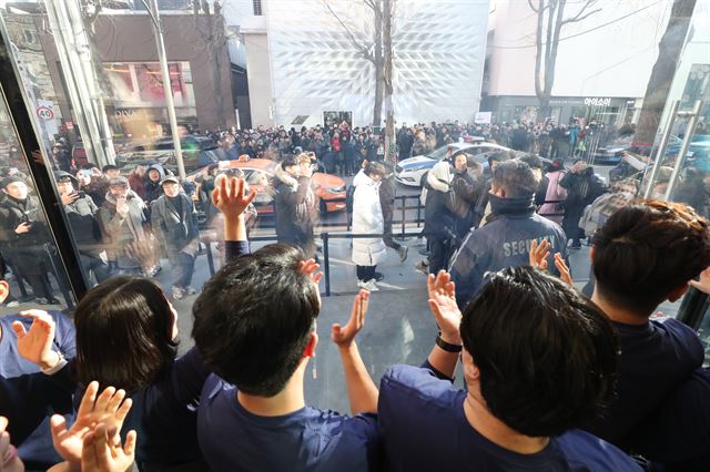 국내 첫 애플스토어 개장일인 27일 오전 서울 강남구 애플 가로수길에서 직원들이 입장 대기중인 시민들을 격려하고 있다. 연합뉴스