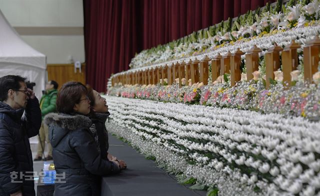 27일 오전 경남 밀양시 삼문동에 마련된 밀양 세종병원 화재 희생자 합동분향소에서 유가족들이 영정 앞에서 흐느끼고 있다. 밀양=류효진기자