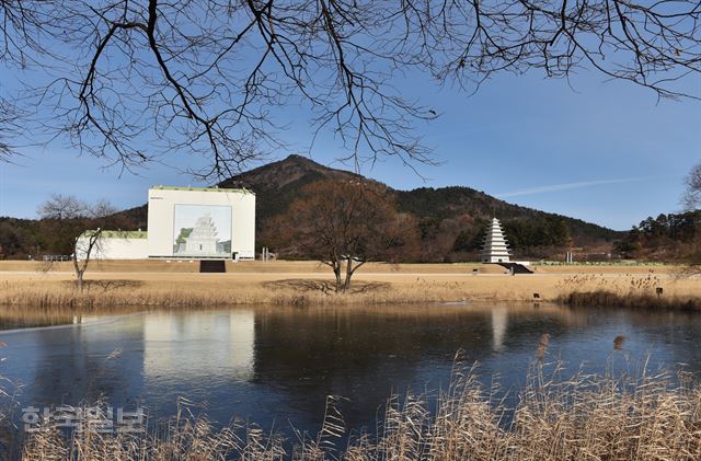 미륵사지 서탑은 복구공사를 위한 가건물 안에 갇혀 있고, 1992년 복원한 동탑이 매끈한 모습으로 서 있다.