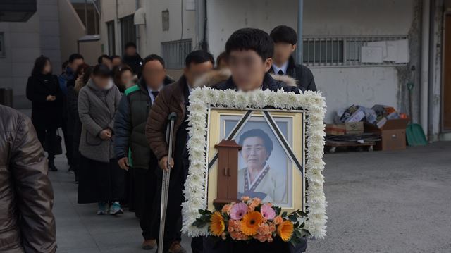 밀양세종병원 화재 참사로 숨진 강귀남(89)씨의 유족들이 한솔병원 장례식장에서 침통한 표정을 지으며 영정을 들고 이동하고 있다. 밀양=김재현 기자