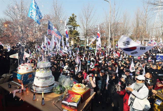 박근혜 전 대통령의 67번째 생일인 2일 오전 박 전 대통령이 구속 수감 중인 경기도 의왕시 서울구치소 앞에서 열린 생일 축하 집회에 참석한 보수단체 회원과 지지자들이 폭죽에 불을 붙이고 있다. 연합뉴스