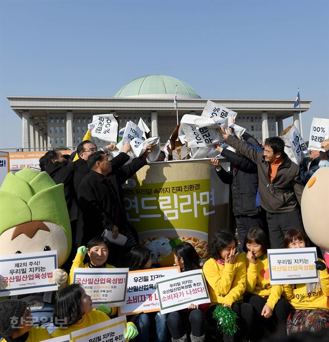 2일 서울 여의도 국회에서 열린 국산밀산업육성법 제정 추진 기념식에서 이개호 국회의원, 이정찬 국산밀산업협회 이사장, 우리밀 생산자 및 소비자 등이 대형 우리밀 컵라면 모형의 속을 우리밀 알곡으로 채우는 퍼포먼스를 하고 있다. 서재훈기자