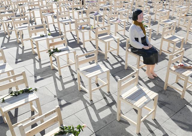 지난해 12월 27일 서울 종로구 옛 일본대사관 앞에서 작년 마지막 수요집회를 마친 참가자들이 서울 광화문광장으로 행진한 뒤 '빈 의자에 새긴 약속'이라는 주제로 소녀상을 설치하고 300개의 빈 의자에 헌화했다. 연합뉴스