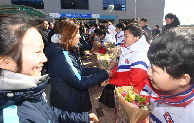 지난달 25일 대한민국 여자 아이스하키 선수단이 평창동계올림픽에서 단일팀으로 함께 뛸 북한 선수단을 처음으로 만나 꽃다발을 건네며 환영하고 있다. 사진공동취재단