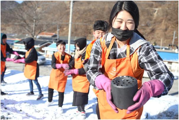 한화해피프렌즈 청소년봉사단에 속한 한 여자 고등학생이 연탄을 나르고 있다. 한화생명 제공