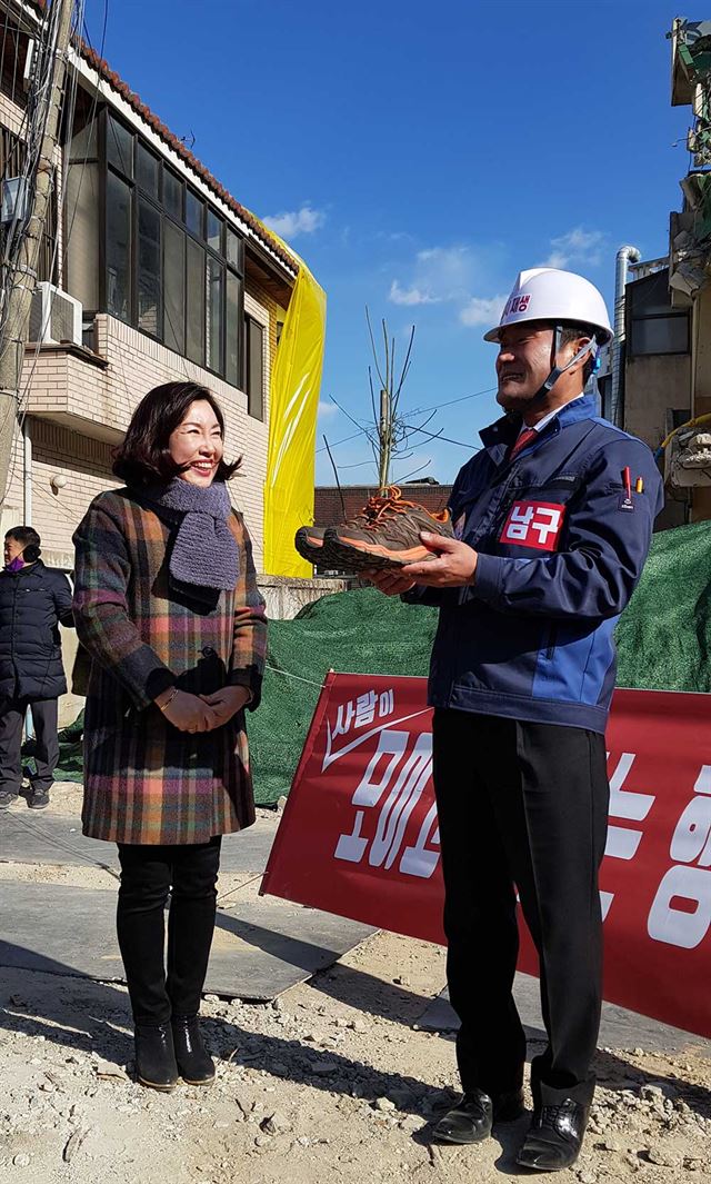 권오섭 대구 남구 새마을회장이 5일 오후 대구 남구 봉덕동 효성타운 북문 신촌지구 재개발현장에서 지방선거 대구 남구청장 선거 출마 의사를 밝히고 남구 주민에게 작업화를 건네받고 있다. 윤창식기자 csyoon@hankookilbo.com