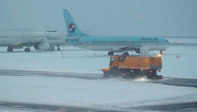 제주지역에 많은 눈이 내린 지난 5일 오전 제주시 제주국제공항 활주로에서 공항 관계자들이 제설작업을 하고 있다. 뉴스1.