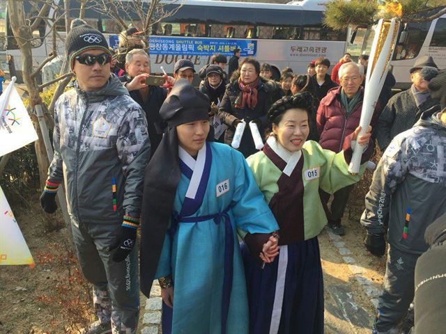 8일 오전 올림픽 빙상경기 개최도시인 강원 강릉시 사모정(思母亭)에서 실제 모자인 금태연(어머니)씨와 김남희(아들)씨가 조선시대 복장으로 신사임당과 율곡 역을 맡아 성화 봉송을 진행했다. 백교효문화선양회 제공