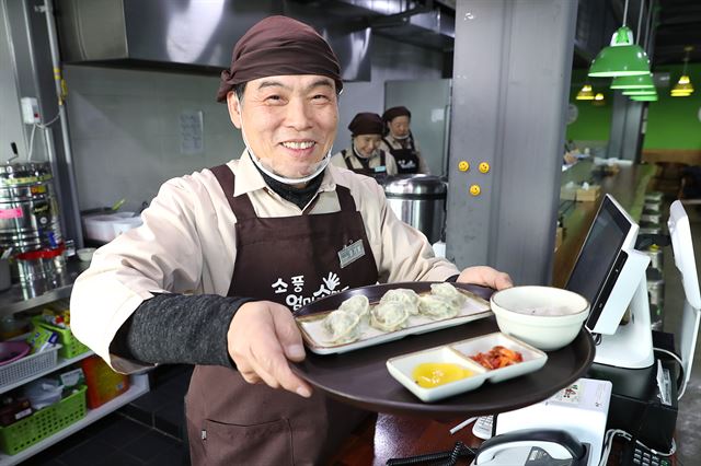 엄기범(64)씨가 서울 성동구 왕십리로 ‘엄마 손만두 소풍’에서 손님이 주문한 만두를 내오고 있다. 성동구 제공