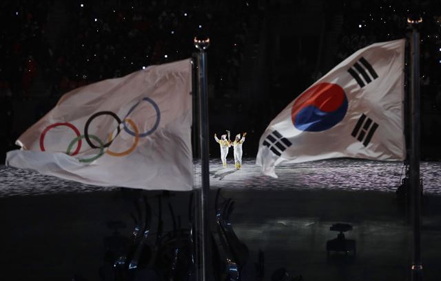 평창동계올림픽 개막식에서 아이스하키 선수들이 성화들 들고 점화대로 오르고 있다. AP Photo