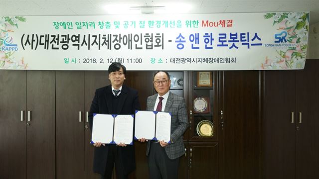 송창재(왼족) 송앤한로봇틱스 사업부문장과 박태규 대전지체장애인협회장이 12일 실내공기질 개선사업을 위한 MOU를 맺었다.