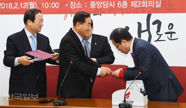 자유한국당 홍준표 대표가 12일 여의도 당사에서 열린 '늘푸른 한국당' 입당식에서 이재오 대표로부터 입당원서를 받고 있다. 오대근기자 inliner@hankookilbo.com