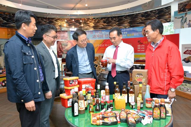 황숙주(오른쪽에서 두 번째) 전북 순창군수가 직원들과 함께 토종 미생물을 활용한 청국장, 고추장토마토 소스 등 다양한 제품을 살펴 보고 있다. 순창군 제공