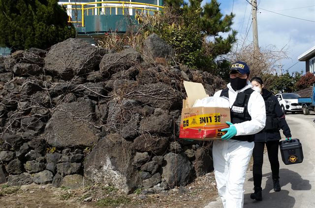 제주동부경찰서는 게스트하우스에 투숙했다가 목이 졸려 살해된 20대 여성의 시신을 11일 발견하고, 유력 용의자인 게스트하우스 관리인을 쫓고 있다. 사진은 12일 오전 경찰이 사건이 발생한 게스트하우스에서 압수수색을 마치고 증거품을 가지고 나오고 있다. 연합뉴스.