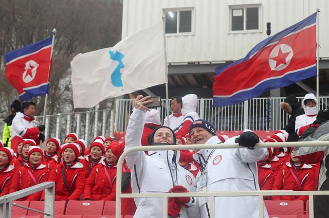 14일 오전 강원도 평창 용평알파인경기장에서 올림픽 알파인스키 여자 회전 경기를 관람하기 위해 방문한 외국인들이 북측 응원단 앞에서 기념촬영을 하고 있다. 연합뉴스