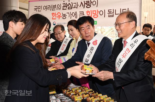 농협이 농림축산식품부·한우자조금관리위원회와 함께 14일 서울역 앞에서 귀성객들을 대상으로 우리 축산물 소비 홍보를 위한 나눔 행사 가두캠페인을 진행했다. 김태환 농협 축산경제대표이사(오른쪽), 민경천 한우자조금관리위원회 위원장(오른쪽 두번째)등이 귀성객들에게 간식용 한우육포, 구운 계란 등을 나눠주고 있다.배우한 기자