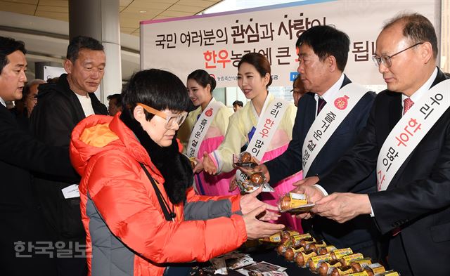 농협이 농림축산식품부·한우자조금관리위원회와 함께 14일 서울역 앞에서 귀성객들을 대상으로 우리 축산물 소비 홍보를 위한 나눔 행사 가두캠페인을 진행했다. 김태환 농협 축산경제대표이사(오른쪽), 민경천 한우자조금관리위원회 위원장(오른쪽 두번째)등이 귀성객들에게 간식용 한우육포, 구운 계란 등을 나눠주고 있다.배우한 기자