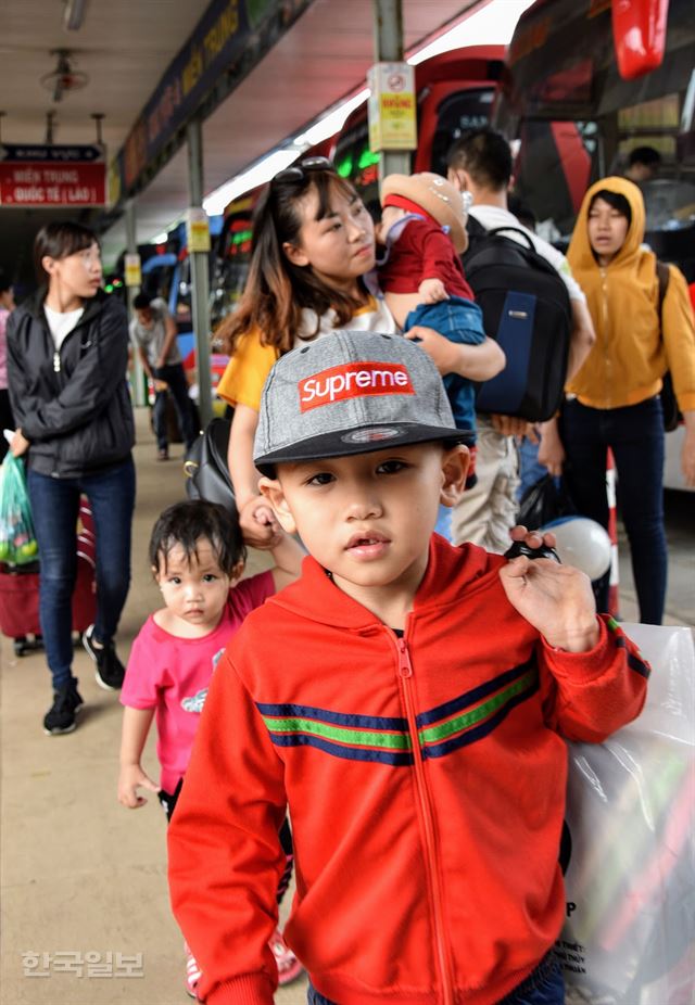 베트남의 공식 설 연휴가 시작되기 하루 전인 13일 오후 호찌민동부버스터미널에서 한 가족이 버스승강장으로 이동하고 있다. 엄마 도움 없이도 자신의 짐을 들고 가는 모습, 짐을 맨 채 어린 아이들을 안고 걸리는 아이 엄마의 얼굴에서 힘든 모습은 찾아 볼 수 없다.